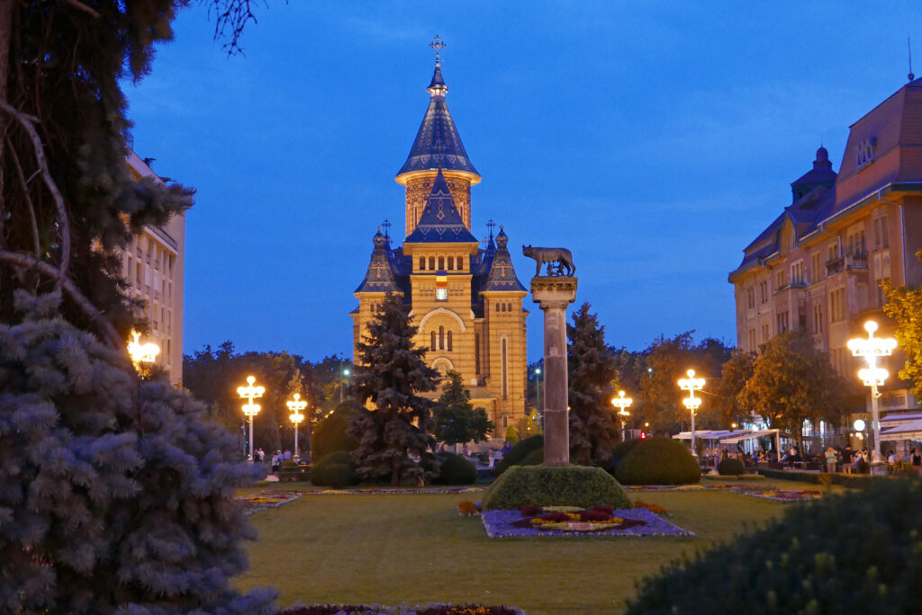 Metropolitankathedrale von Timișoara mit Kapitolinischer Wölfin (rumänisch: Lupa Capitolina). Sie zeigt die Wölfin, die nach der römischen Sage die Zwillinge Romulus und Remus säugte – ein Symbol für die Herkunft des römischen Volkes. Solche Statuen stehen in mehreren Städten Rumäniens und symbolisieren die sprachlichen und kulturellen Wurzeln des Landes im römischen Erbe.